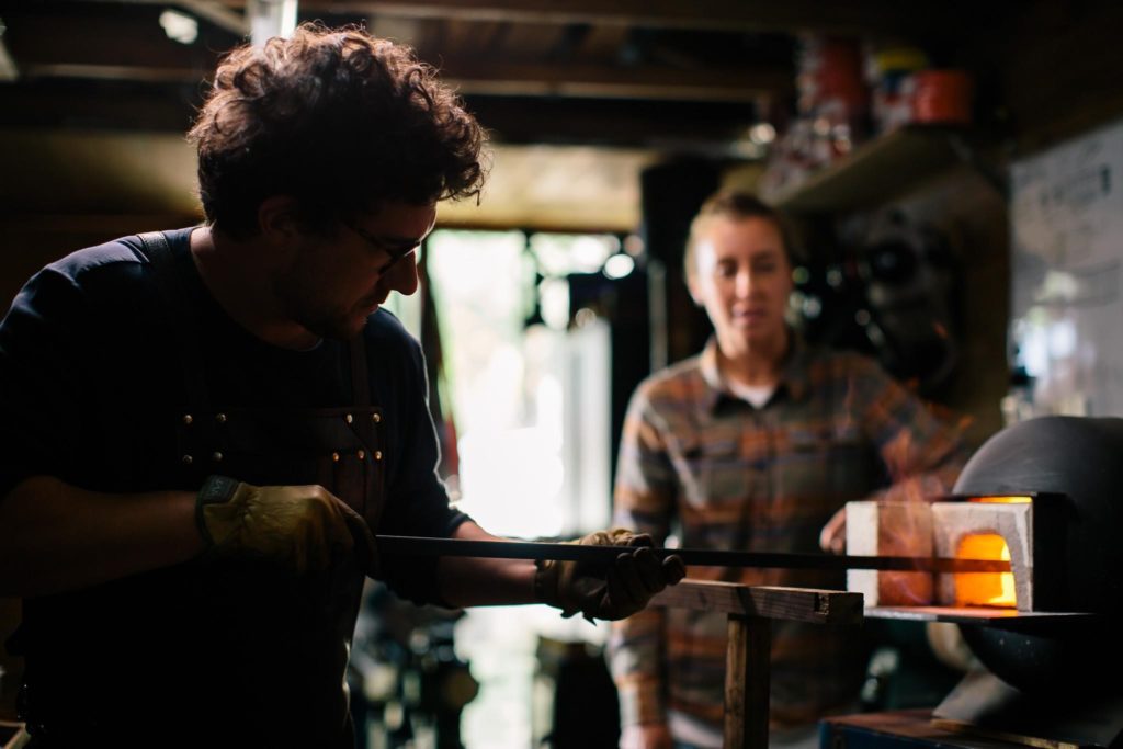 a man taking out baked goods from a woodfire oven