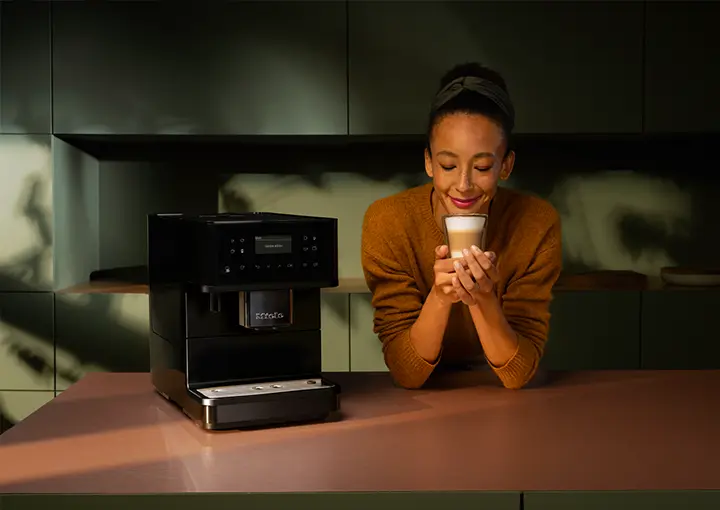 a person enjoying a coffee made with a Miele coffee machine