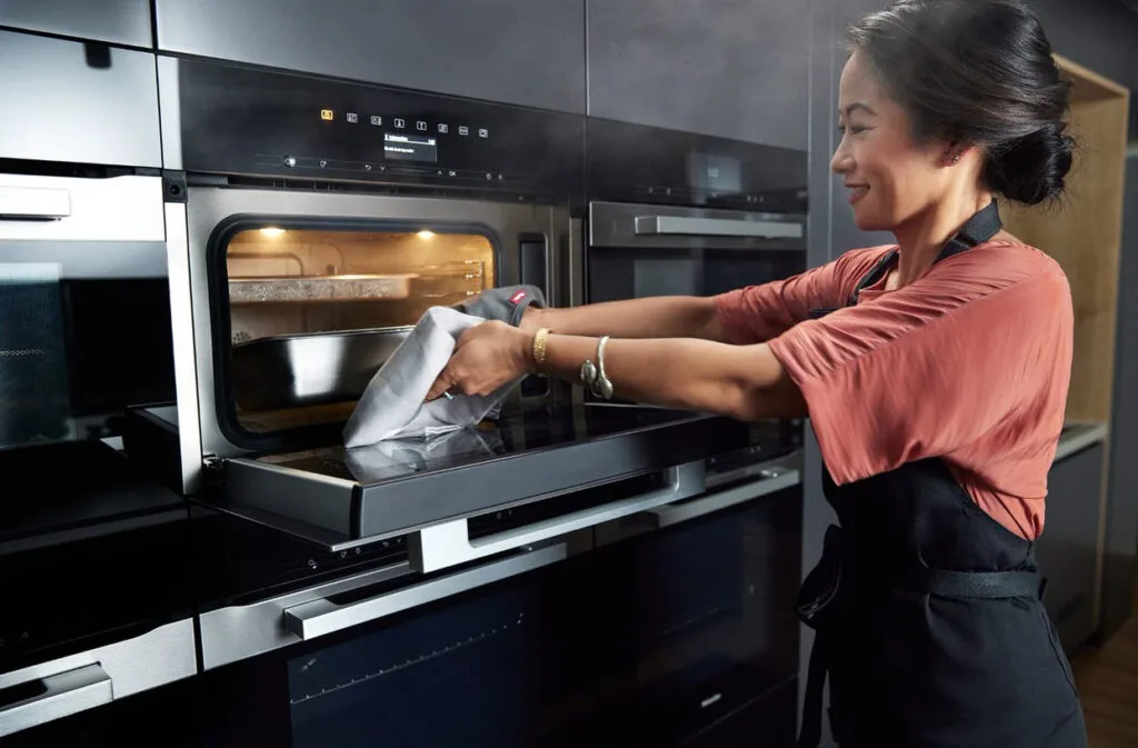 Palisa pulling out a dish from a Miele steam oven